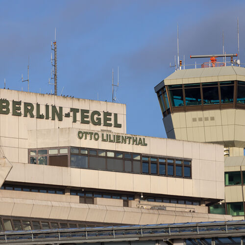 Eine Außenansicht des Flughafen Tegels. Zu sehen sind der ehemalige Tower und das Hauptgebäude mit dem grauen Schriftzug: Berlin Tegel Otto Lilienthal.