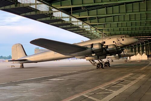 Der silberne Flugzeugnachbau der "Focke-Wulf Fw 200" steht unter dem geöffneten Vordach des Flughafens Tempelhof.