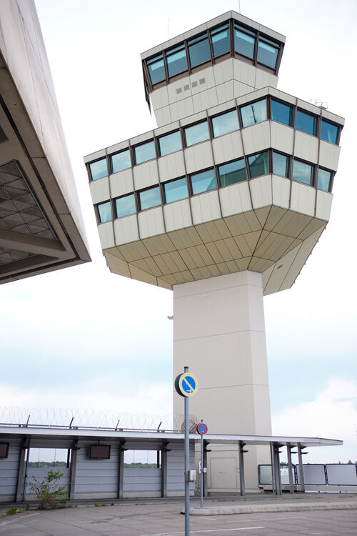 Ein Blickwinkel von unten auf den markanten, mehrstöckigen und weiß gestrichenen Tower des ehemaligen Flughafens Tegel.