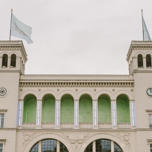 Historisches Museumsgebäude mit zwei Türmen, Arkadenfassade und Fahnen auf dem Dach.