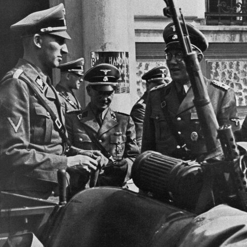 Historische Aufnahme von Reinhard Heydrich vor dem Quartier der Einsatzgruppe II im Gespräch mit weiteren Personen der Einsatzgruppe.